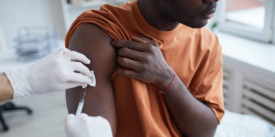 A man receives a vaccine in his arm